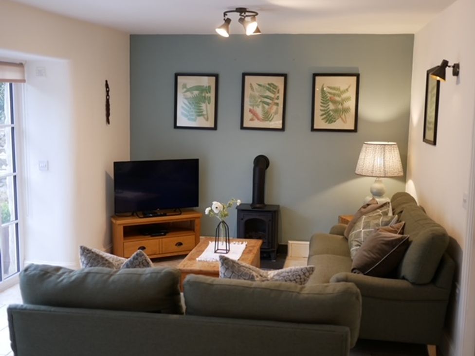 A living room with a sofa and television at The Honey Pot in Garndolbenmaen