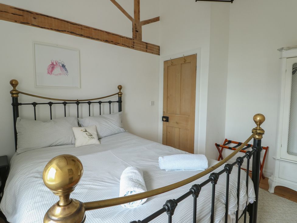 A bedroom with a bed and a door at Tri Raglan Mawr in Beaumaris