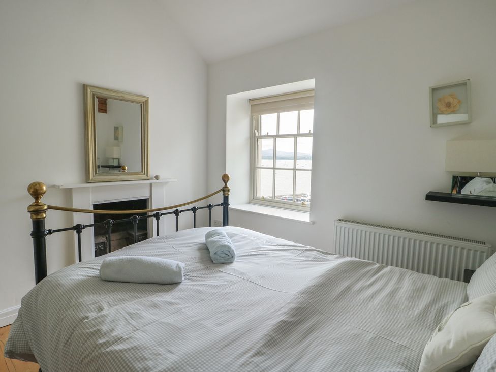 A bedroom with a bed and window at Tri Raglan Mawr Beaumaris