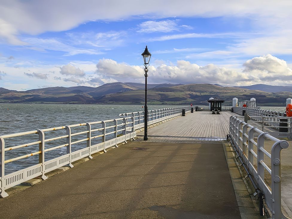 A pier with a lamppost and railing at Tri Raglan Mawr in Beaumaris