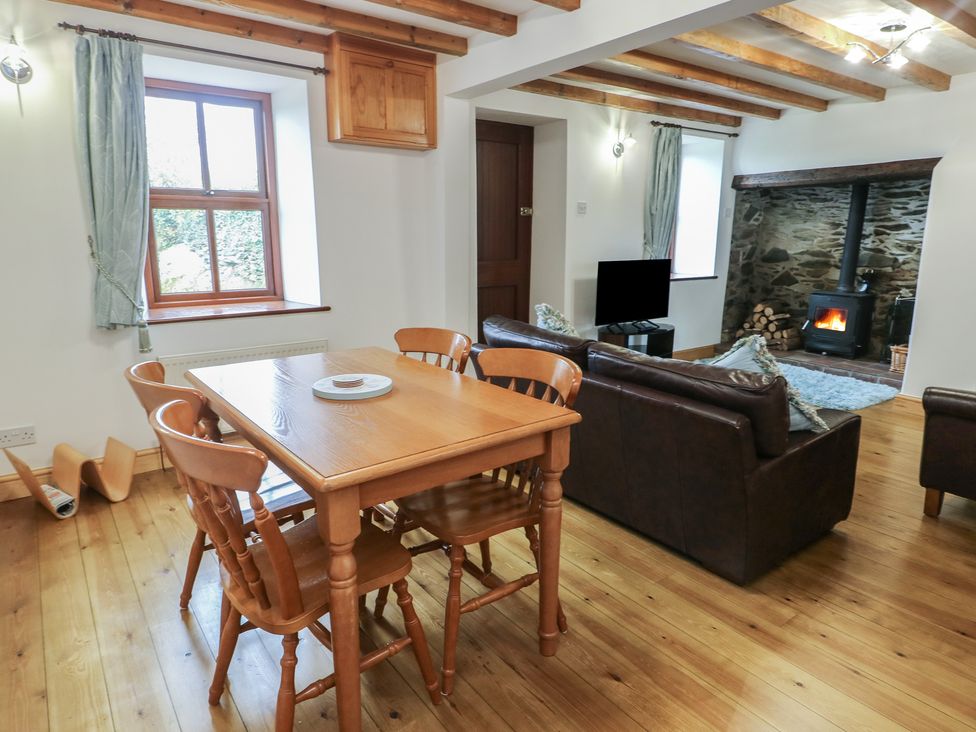 A dining room with a table and chairs at Tyn y Mynydd in Bull Bay