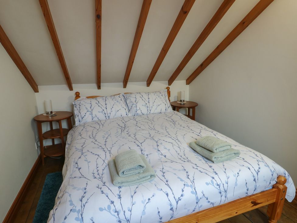 A bedroom with a bed and bedside tables at Tyn y Mynydd in Bull Bay
