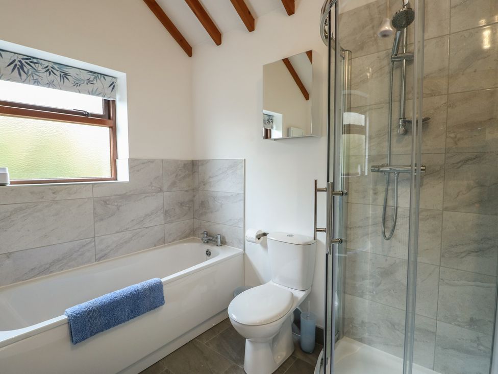 A bathroom with a bathtub and shower at Tyn y Mynydd in Bull Bay