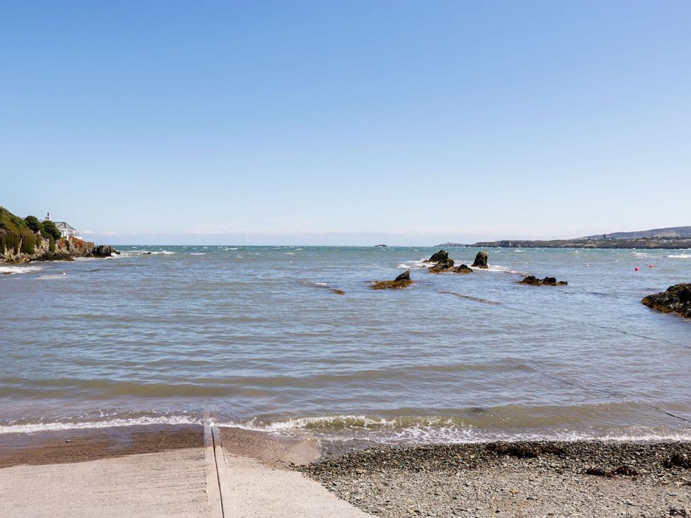 A view of the sea with rocks and a pier at Tyn y Mynydd in Bull Bay