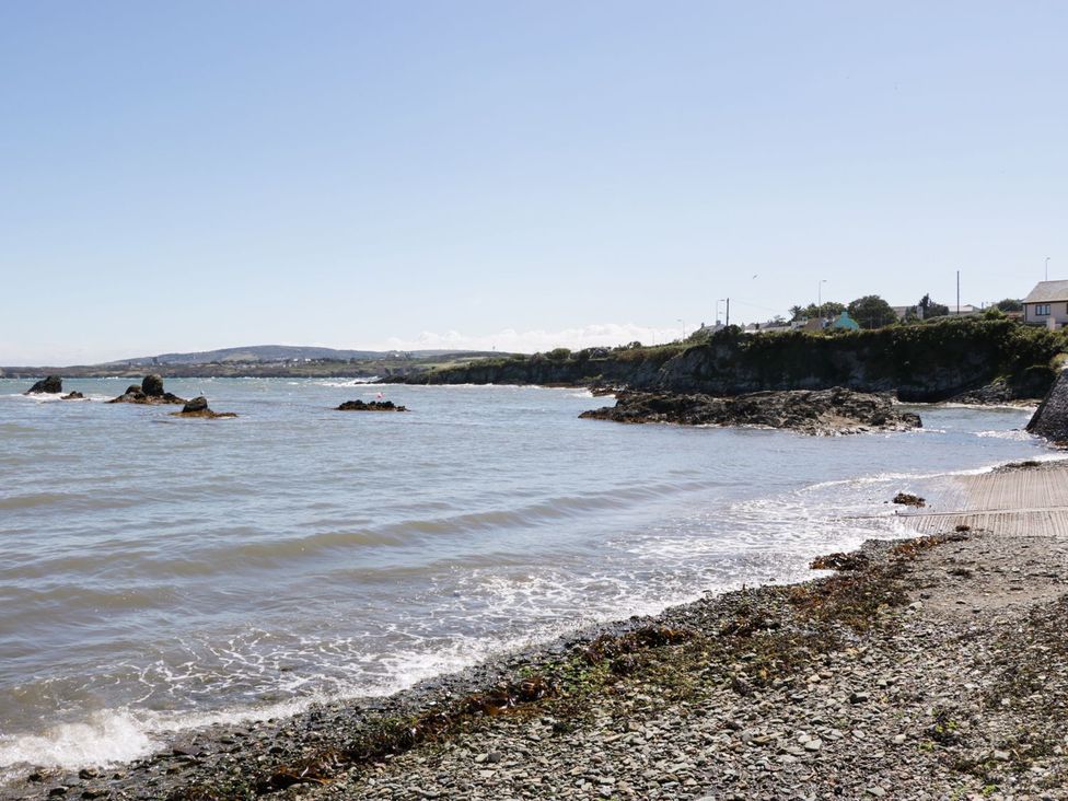 A beach with rocks and water at Tyn y Mynydd in Bull Bay