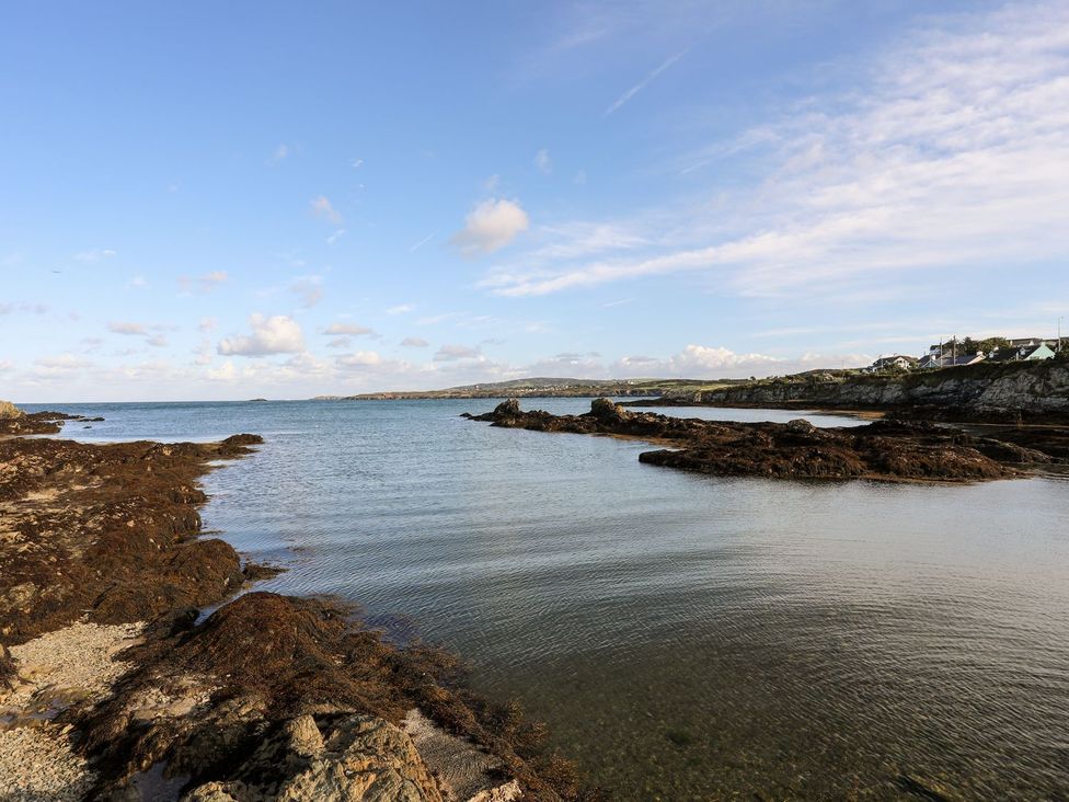 A view of the sea with rocks and seaweed at Tyn y Mynydd in Bull Bay