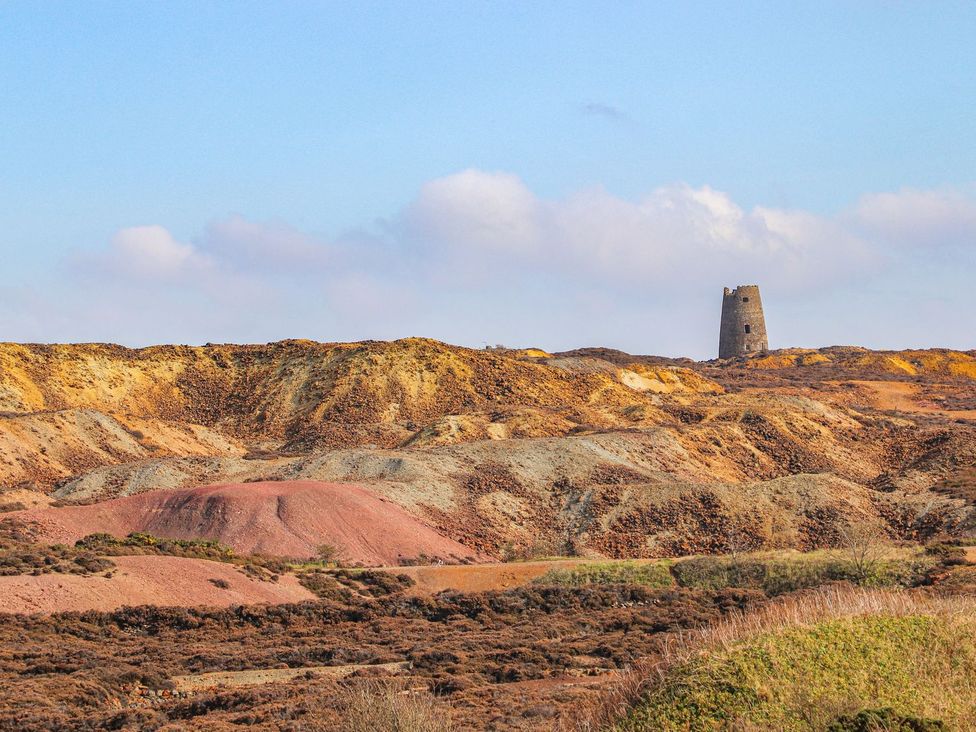 A landscape with a tower and colored mounds at Tyn y Mynydd in Bull Bay