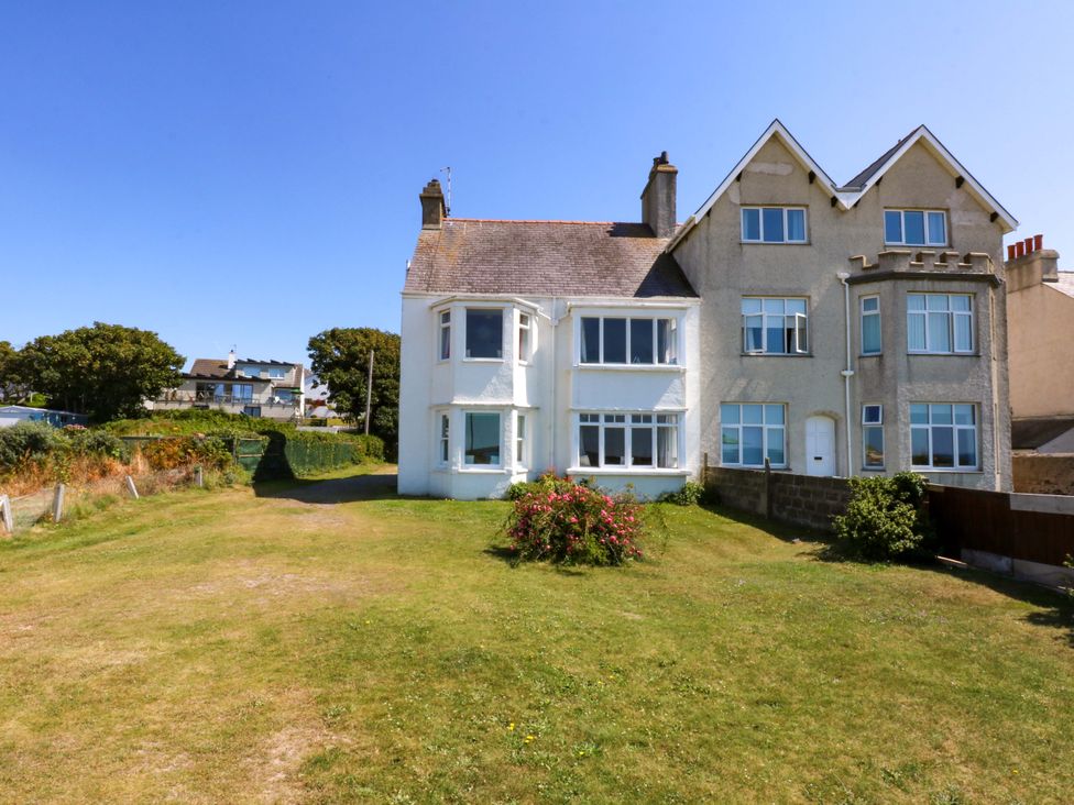 A house with windows and grass area at Windygates in Rhosneigr