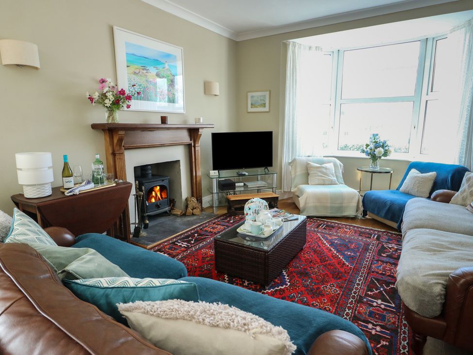 A living room with a fireplace and television at West View in Rhosneigr