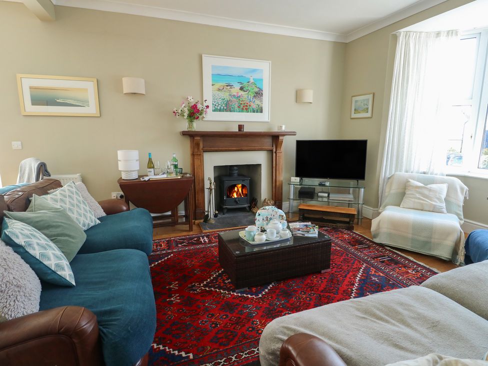 A living room with a fireplace and television at West View in Rhosneigr