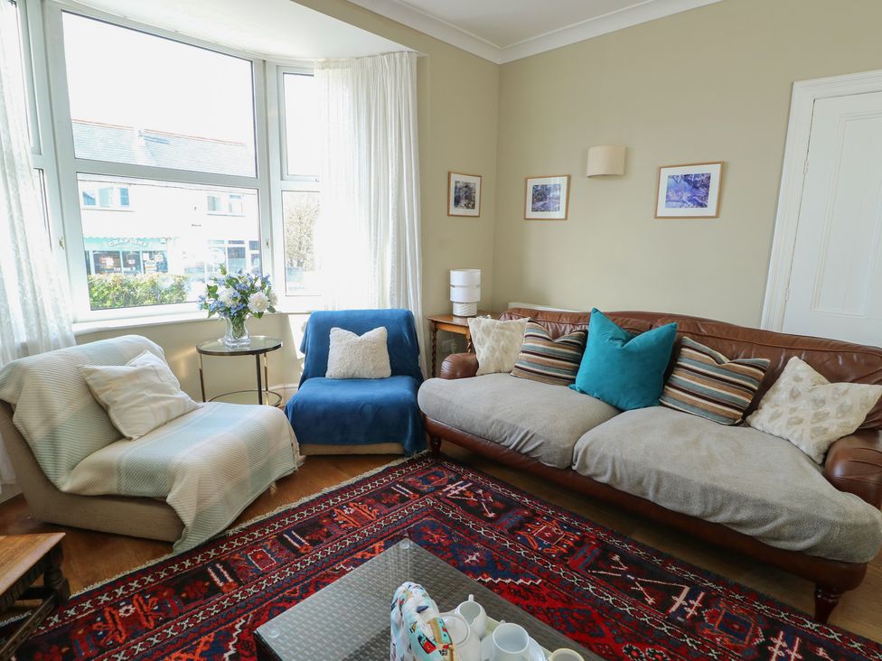 A living room with a sofa and armchair at West View in Rhosneigr