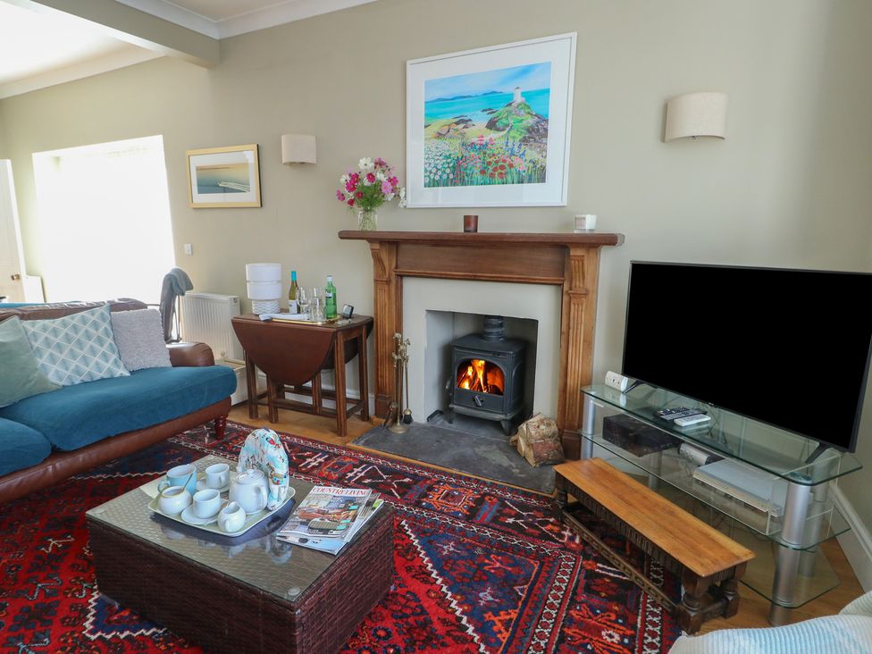 A living room with a fireplace and sofa at West View in Rhosneigr