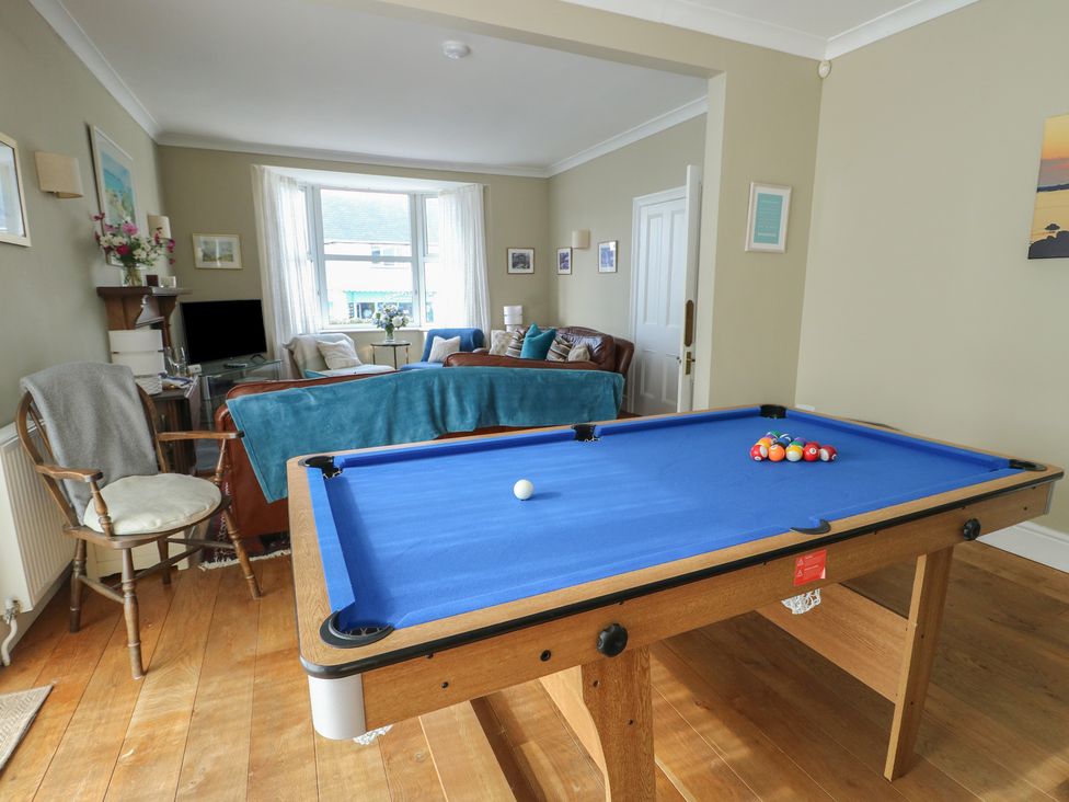 A living room with a pool table and sofa at West View in Rhosneigr