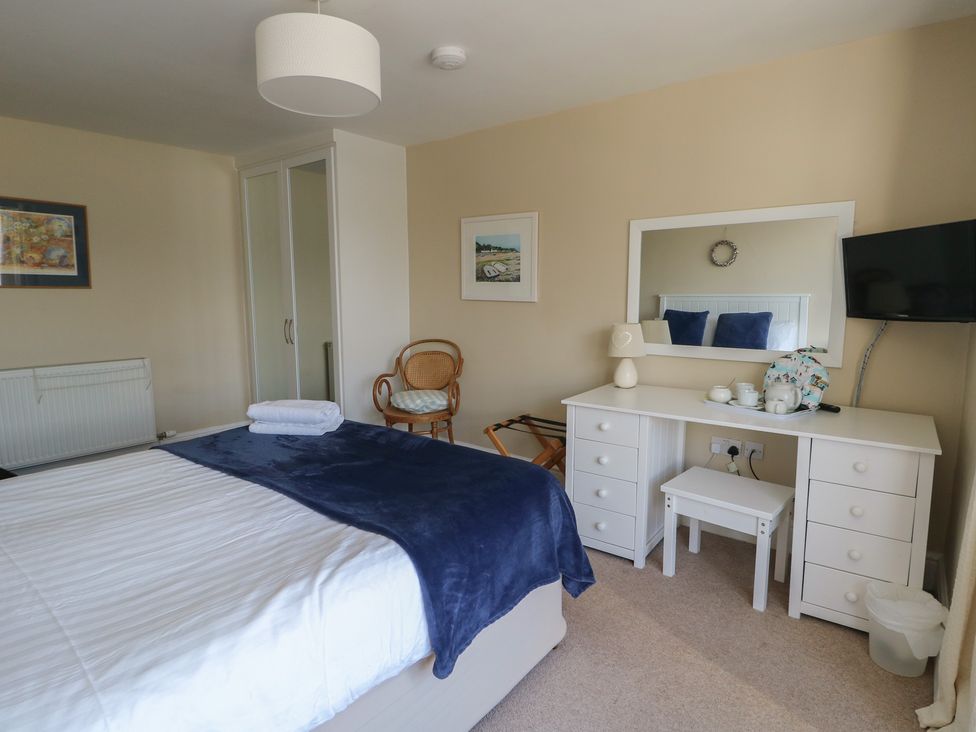A bedroom with a bed and dresser at West View Rhosneigr