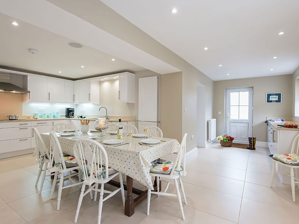 A kitchen with a dining table and chairs at West View in Rhosneigr