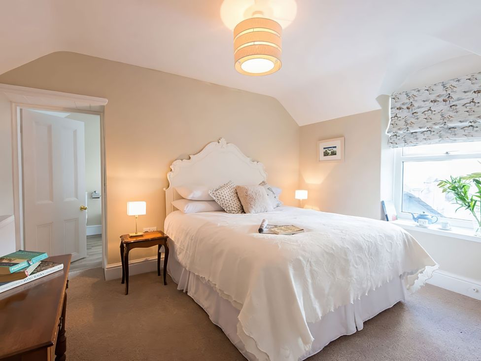 A bedroom with a bed and bedside table at West View in Rhosneigr