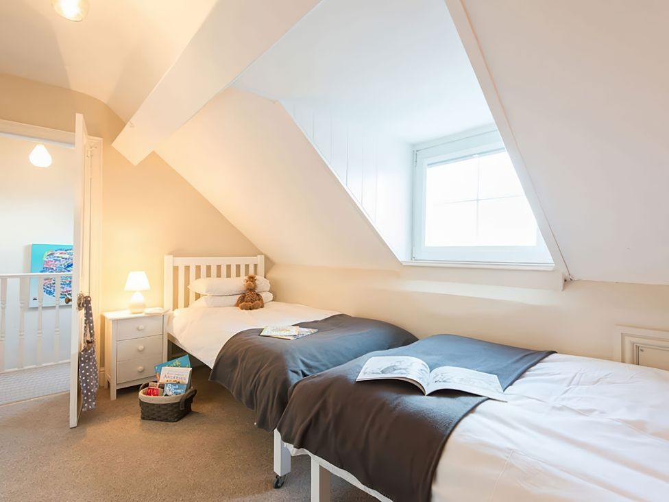 A bedroom with two beds and a window at West View in Rhosneigr