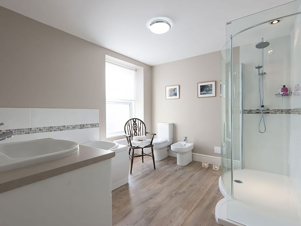 A bathroom with sink, toilet, and shower at West View, Rhosneigr