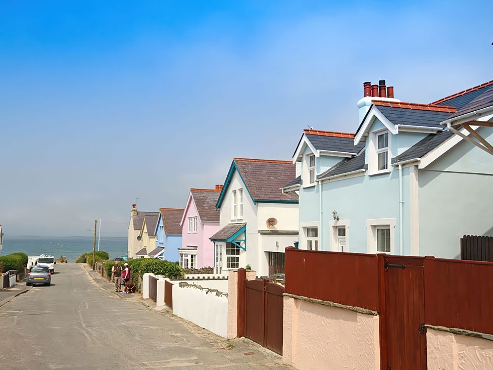 A row of houses along a road with a view of the sea at West View in Rhosneigr
