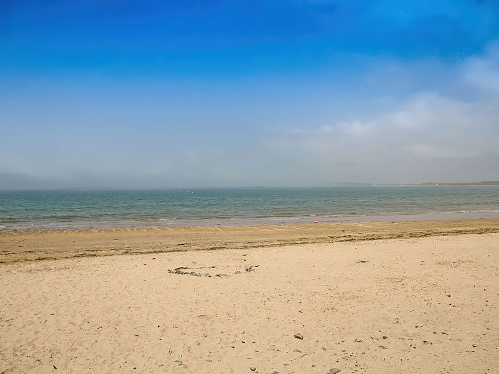 A beach with sand and ocean at West View in Rhosneigr