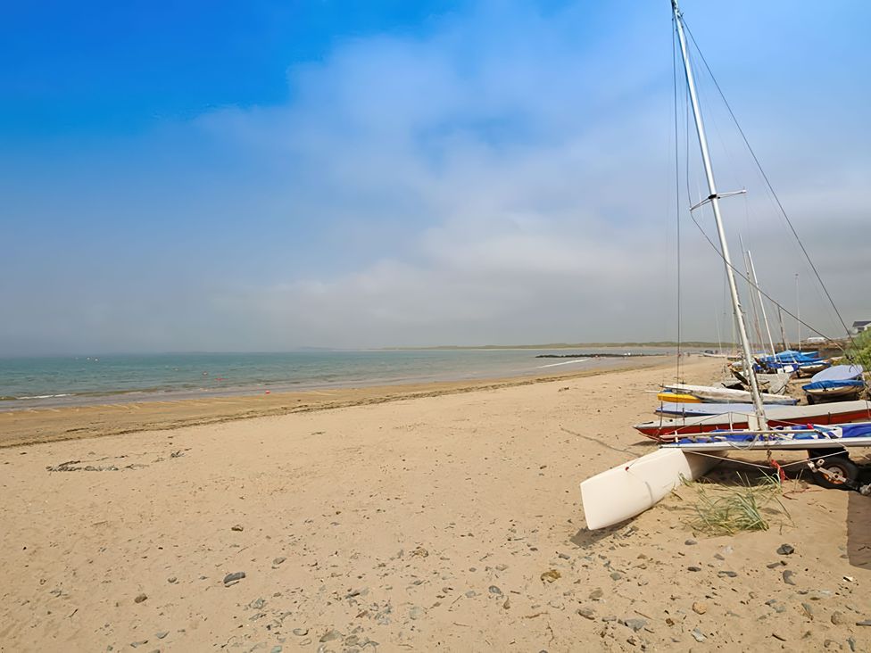 A beach with sailboats along the shoreline at West View in Rhosneigr