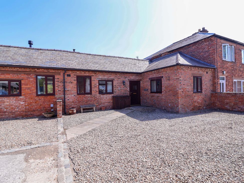 An outdoor view of a brick house with windows and a door at Clwyd Cottage St Asaph