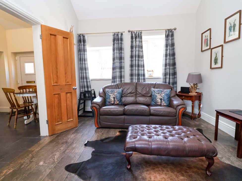 A living room with a sofa and decorative elements at Clwyd Cottage in St Asaph