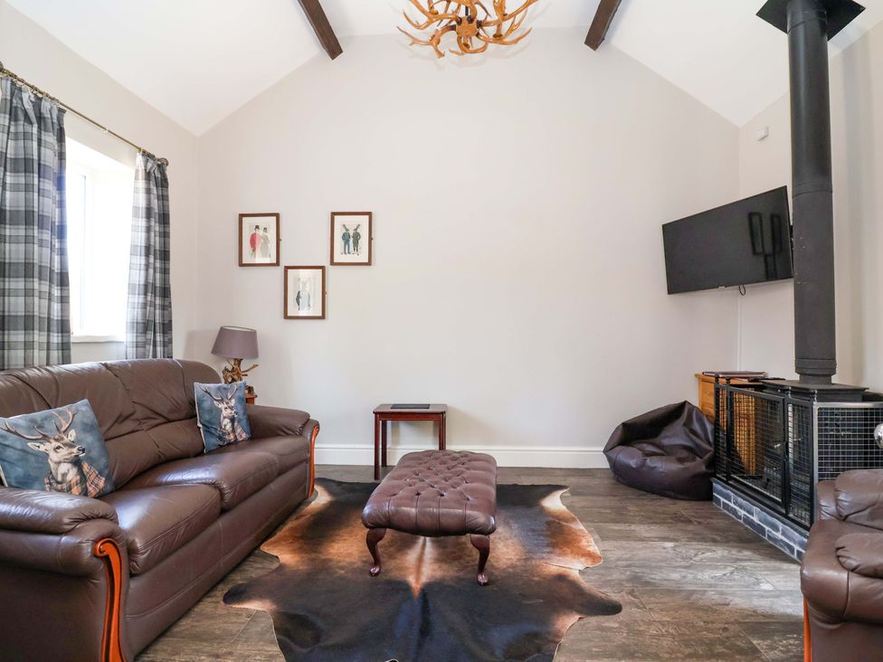 A living room with a sofa and footstool at Clwyd Cottage St Asaph