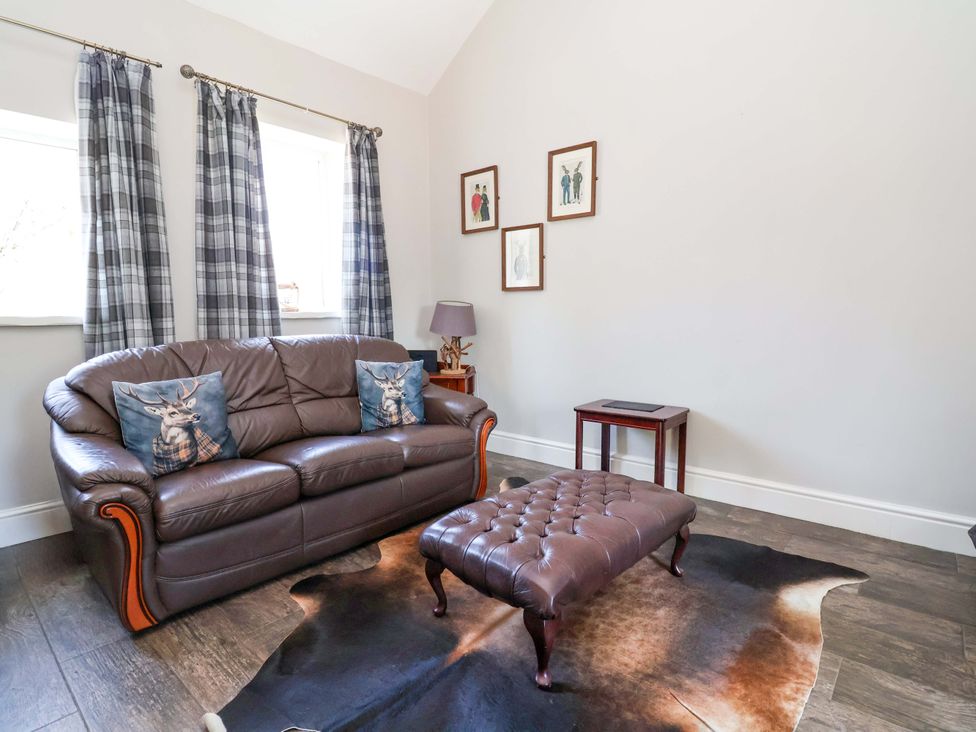 A living room with a sofa and footstool at Clwyd Cottage St Asaph
