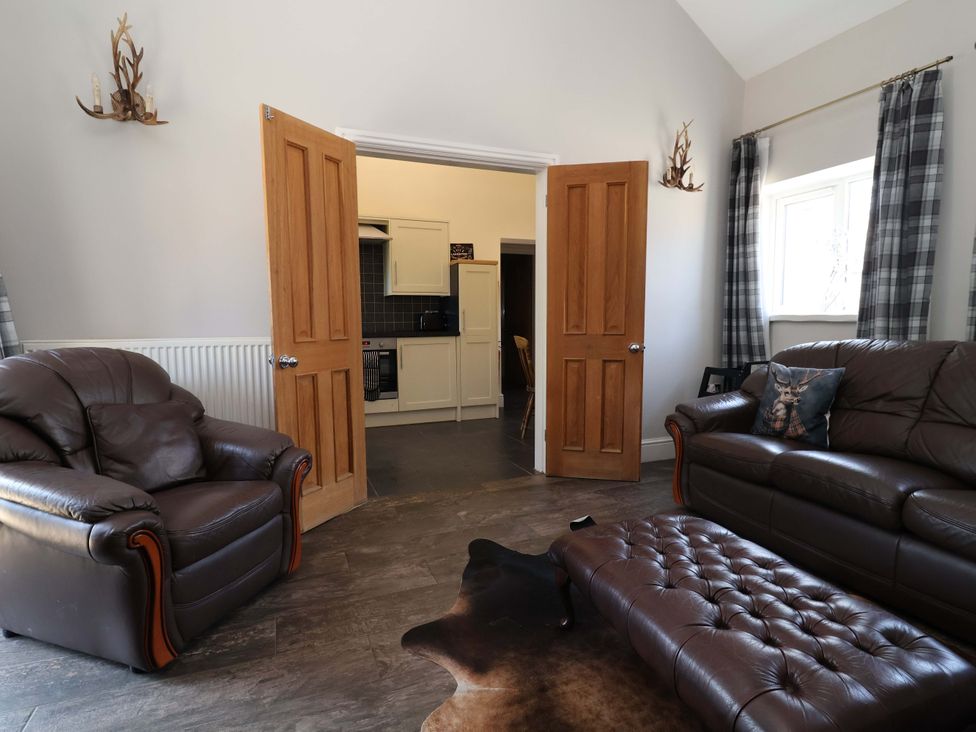 A living room with a sofa and armchair at Clwyd Cottage in St Asaph