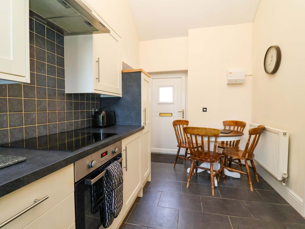A kitchen with a table and chairs at Clwyd Cottage in St Asaph