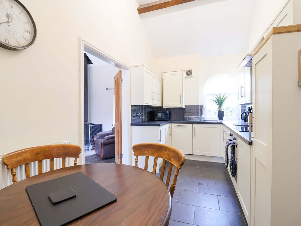 A kitchen with a table and chairs at Clwyd Cottage in St Asaph