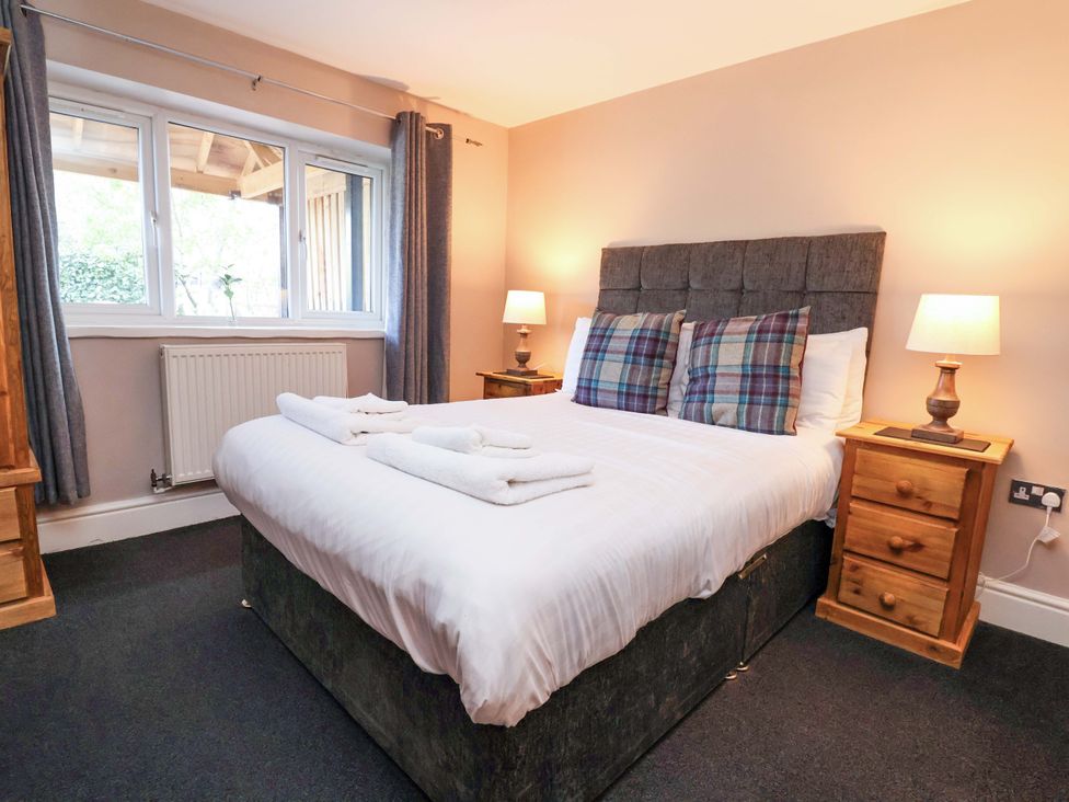 A bedroom with a bed and bedside tables at Clwyd Cottage in St Asaph