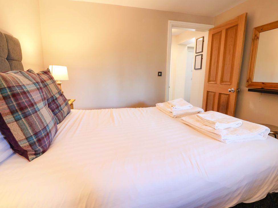 A bedroom with a bed and towels at Clwyd Cottage St Asaph