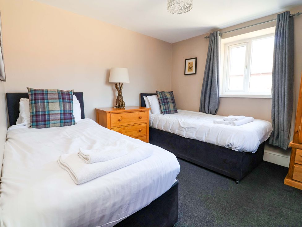 A bedroom with twin beds and a lamp at Clwyd Cottage St Asaph