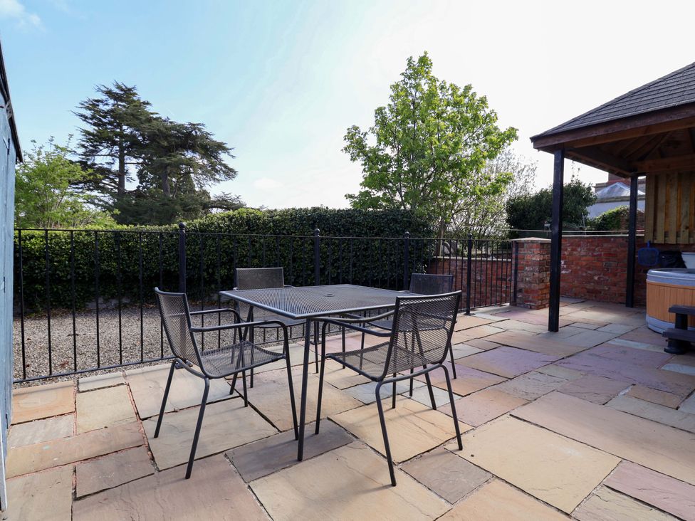 An outdoor seating area with a table and chairs at Clwyd Cottage in St Asaph
