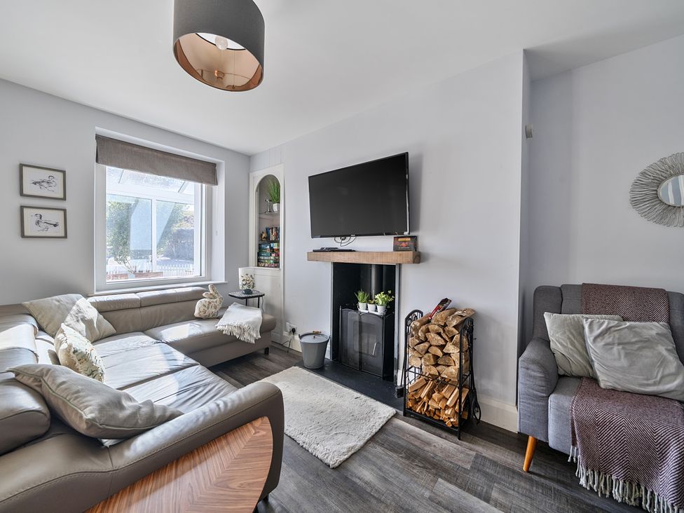 A living room with a sofa and television at Ty Mawr, Great Orme, Llandudno