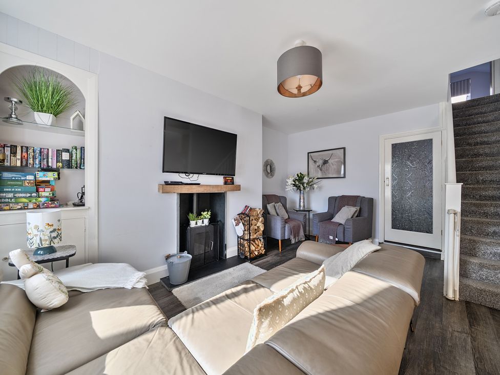 A living room with a sofa and TV at Ty Mawr, Great Orme in Llandudno