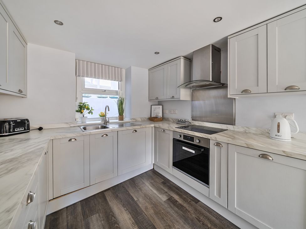 A kitchen with cabinets and appliances at Ty Mawr, Great Orme in Llandudno