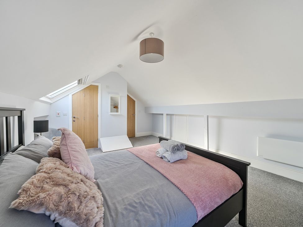 A bedroom with a bed and towels at Ty Mawr, Great Orme in Llandudno
