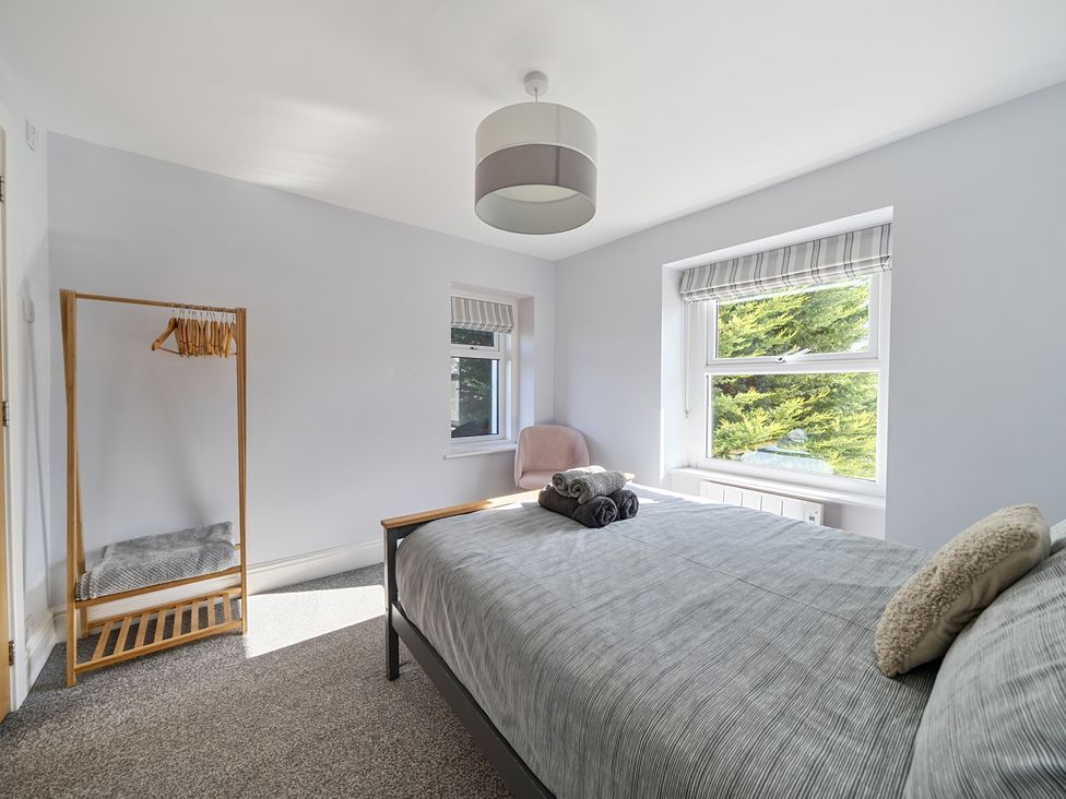 A bedroom with a bed and clothes rack at Ty Mawr, Great Orme in Llandudno