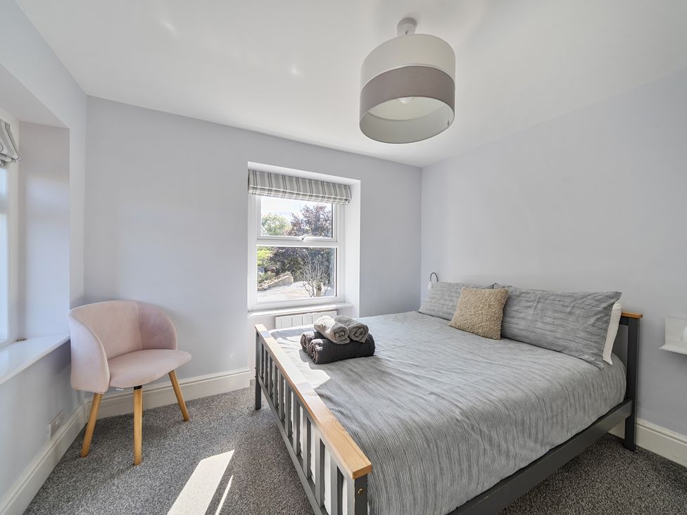 A bedroom with a bed and chair at Ty Mawr, Great Orme in Llandudno