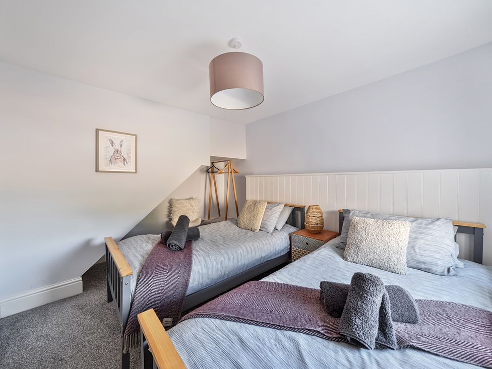 A bedroom with two beds and wall art at Ty Mawr, Great Orme Llandudno