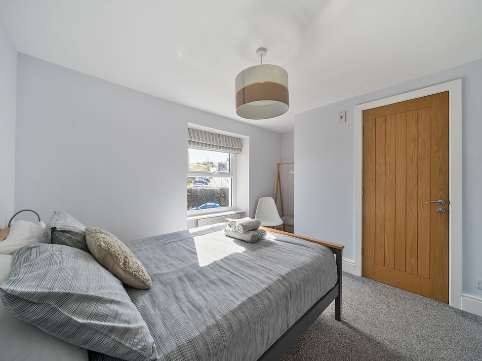 A bedroom featuring a bed with pillows and blankets at Ty Mawr, Great Orme in Llandudno