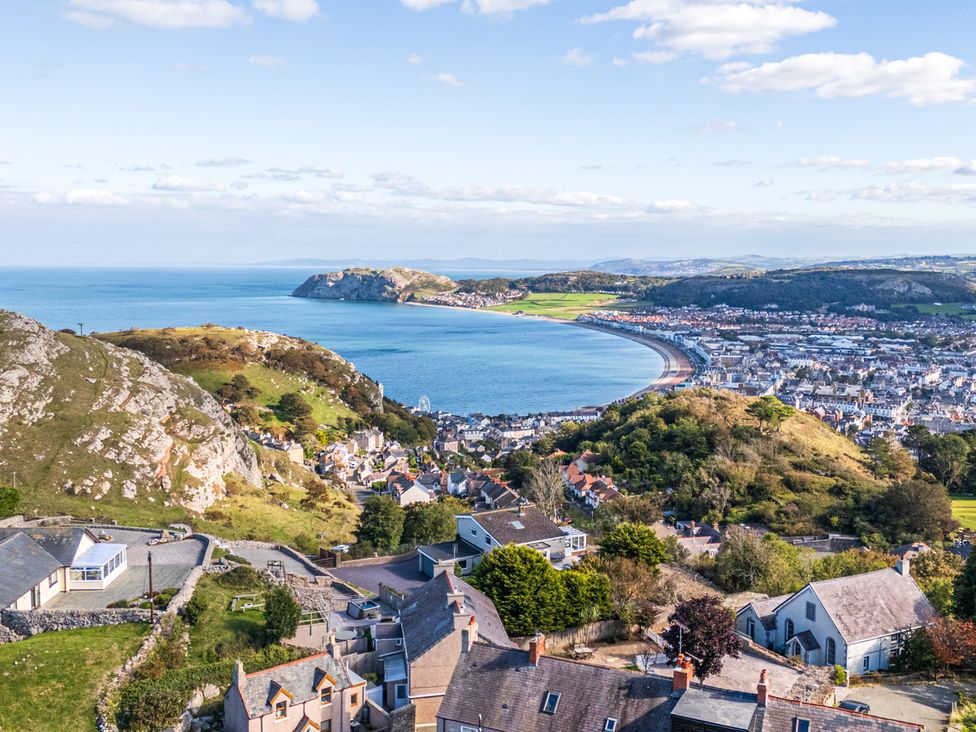 A coastal view of a town with hills and sea at Ty Mawr, Great Orme in Llandudno