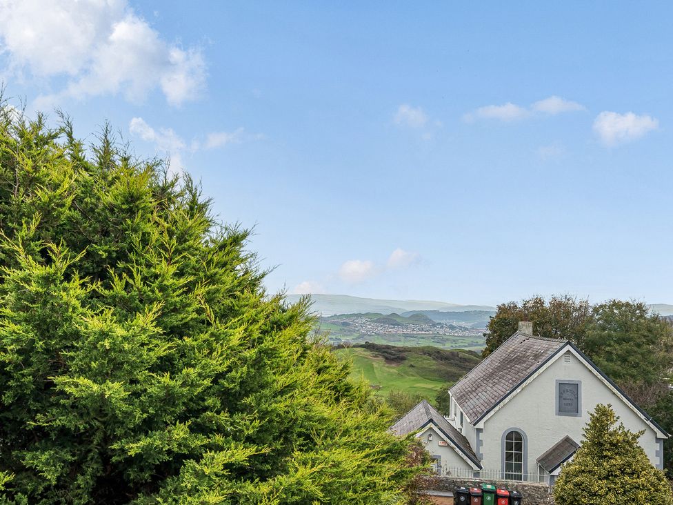 A view of hills and a house with trees at Ty Mawr, Great Orme in Llandudno