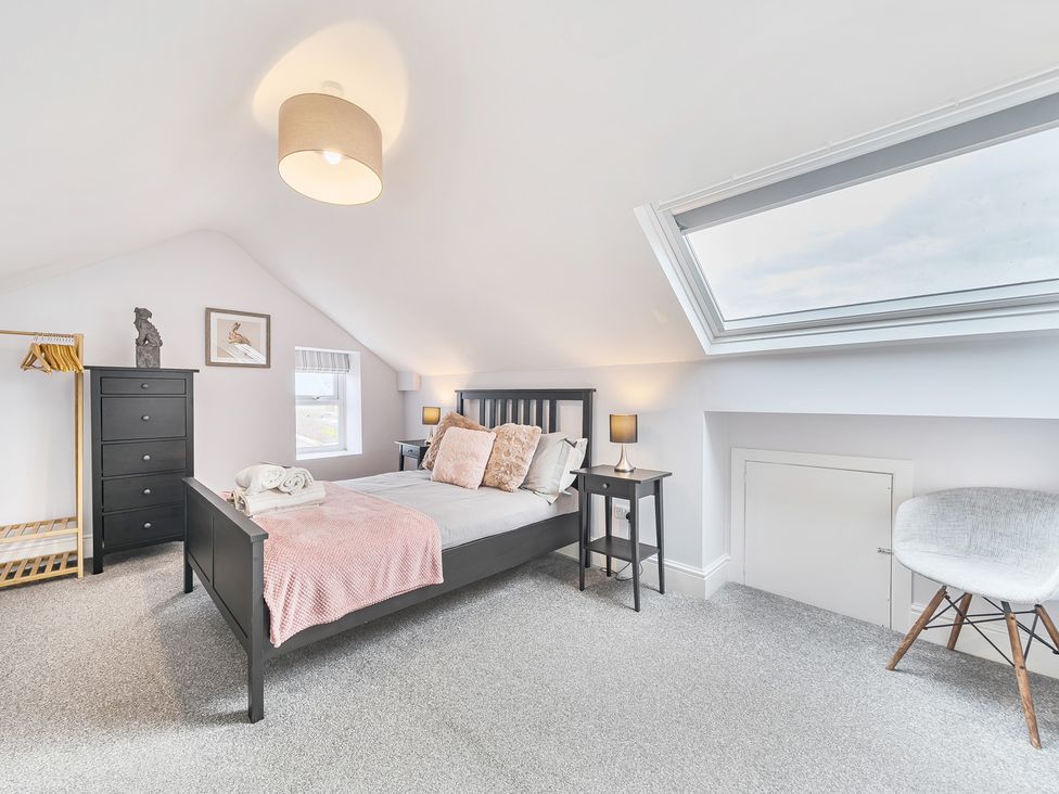 A bedroom with a bed and black furniture at Ty Mawr, Great Orme in Llandudno