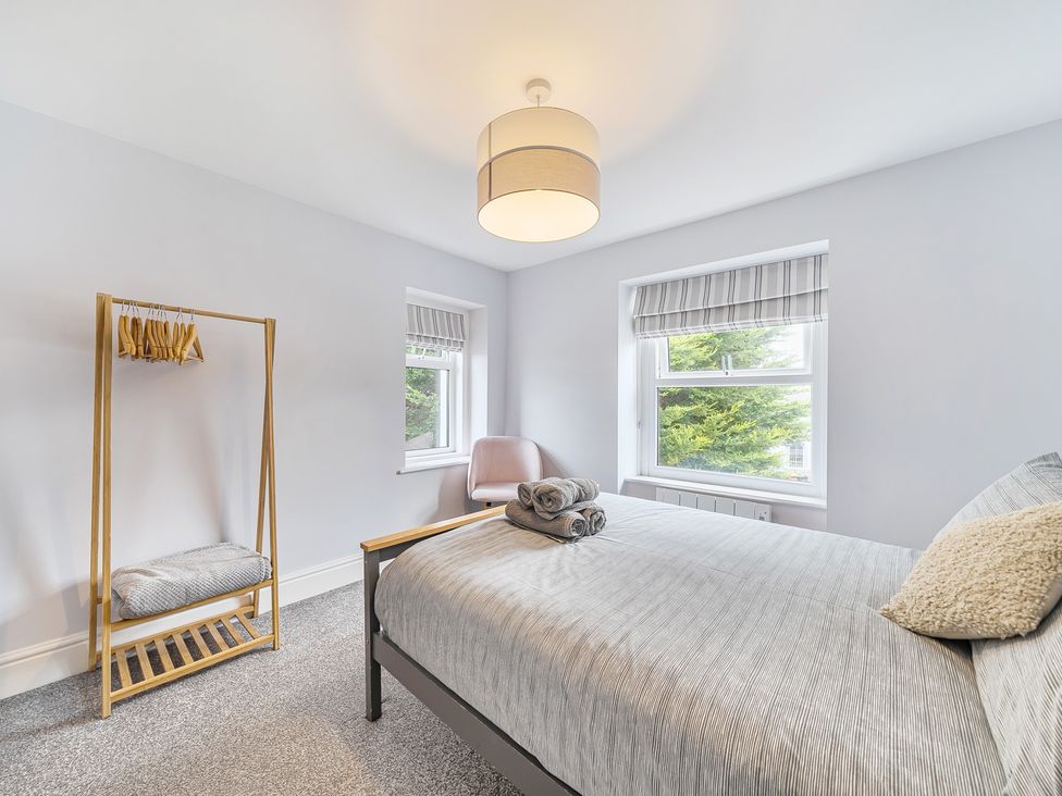 A bedroom with a bed and a clothes rack at Ty Mawr, Great Orme Llandudno