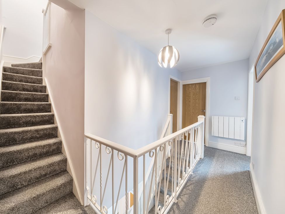 A hallway with stairs and a handrail at Ty Mawr, Great Orme in Llandudno