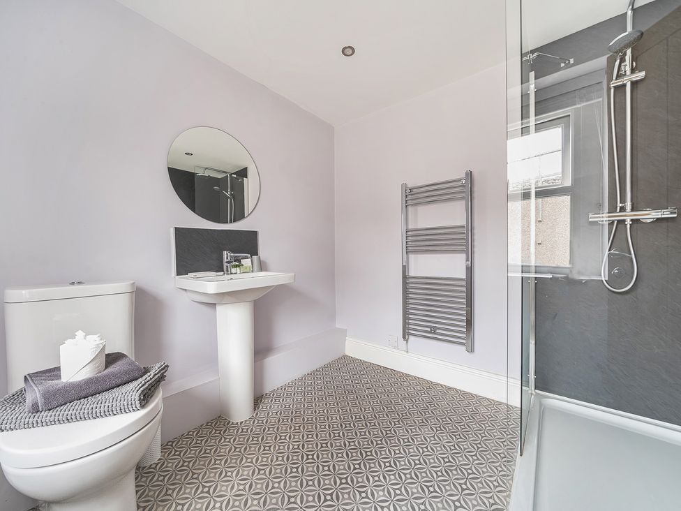 A bathroom with a sink, toilet, and shower at Ty Mawr, Great Orme in Llandudno